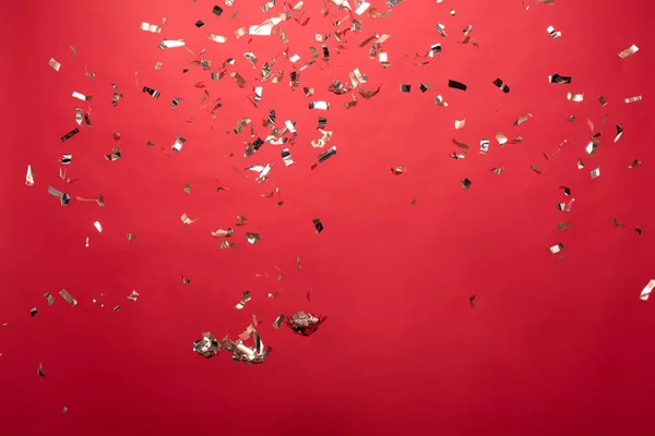 View of golden christmas confetti isolated on red — Stock Photo