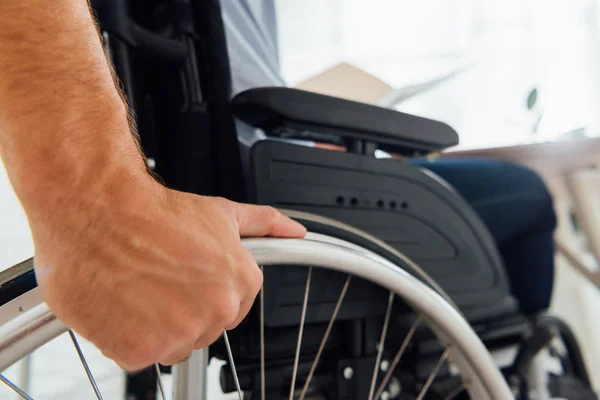 Закрыть человека, держащего колесо инвалидной коляски — стоковое фото