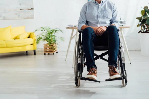 Vue recadrée de l'homme assis en fauteuil roulant dans le salon — Photo de stock