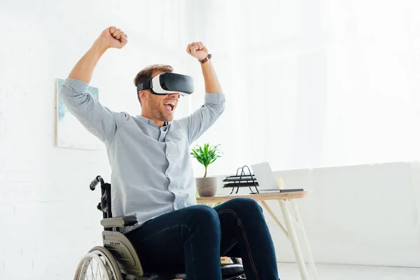 Fröhlicher Mann im Rollstuhl mit Virtual-Reality-Headset im Wohnzimmer — Stockfoto
