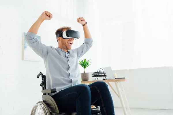 Cheerful man in wheelchair using virtual reality headset in living room — Stock Photo