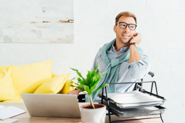 Disabled casual businessman using earphones at home office — Stock Photo