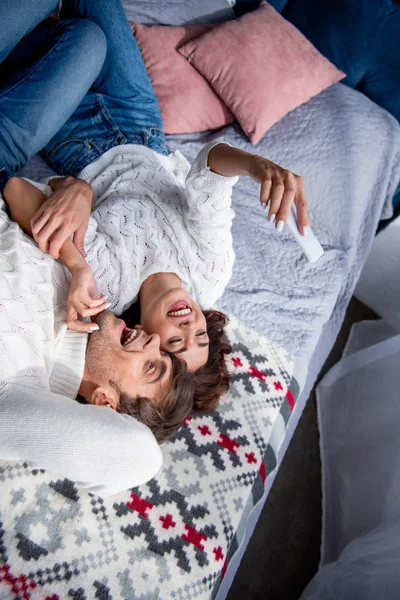 High angle view of attractive girlfriend taking selfie with smiling boyfriend in sweater hugging — Stock Photo