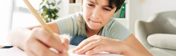 Panoramic shot of kid with dyslexia drawing with pencil — Stock Photo