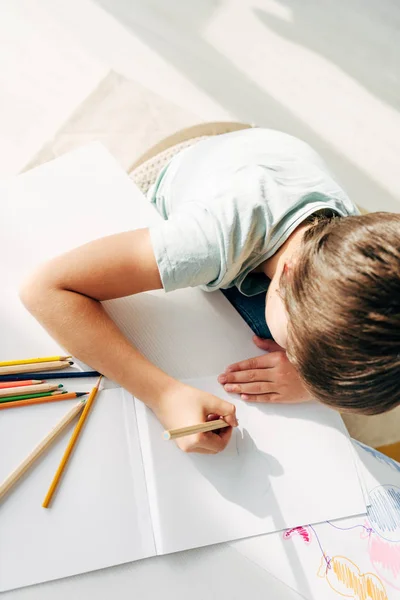Vista superior del niño con dislexia dibujo con lápiz - foto de stock