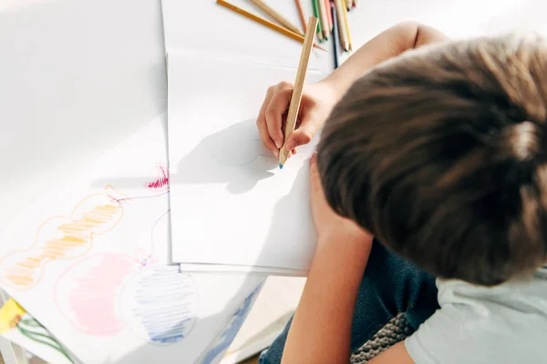 Vista superior del niño con dislexia dibujo con lápiz - foto de stock