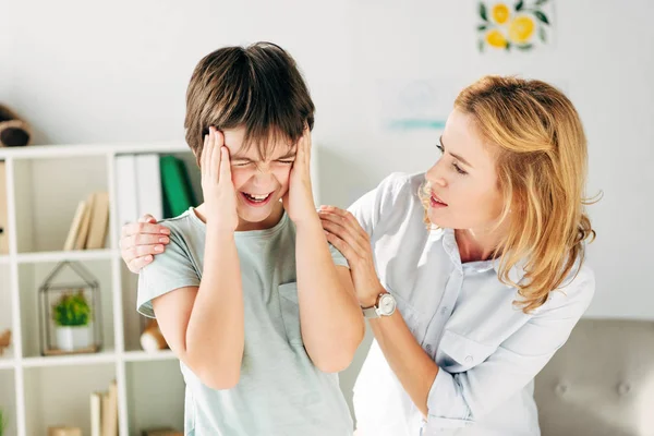 Enfant irrité avec dyslexie et psychologue de l'enfant le calmer — Photo de stock