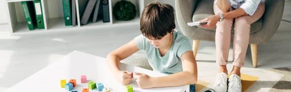 Plano panorámico de niño irritado con dislexia jugando bloques de construcción - foto de stock