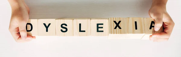 Plan panoramique d'enfant tenant des cubes en bois avec dyslexie lettrée — Photo de stock