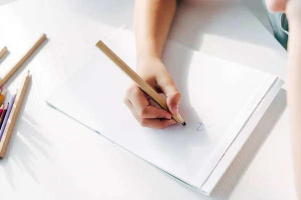 Обрезанный вид ребенка с дислексией рисунок на бумаге с карандашом — стоковое фото