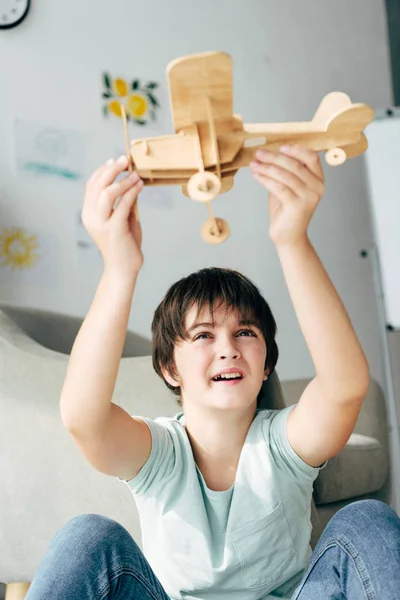 Mignon enfant avec dyslexie jouer avec avion en bois — Photo de stock