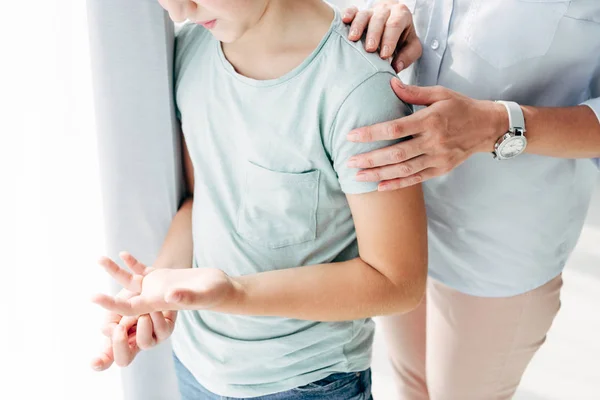 Vista recortada de niño psicólogo abrazo niño con dislexia - foto de stock