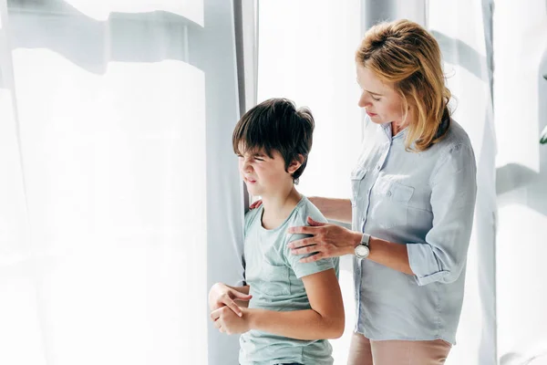 Child psychologist hugging and talking to kid with dyslexia — Stock Photo