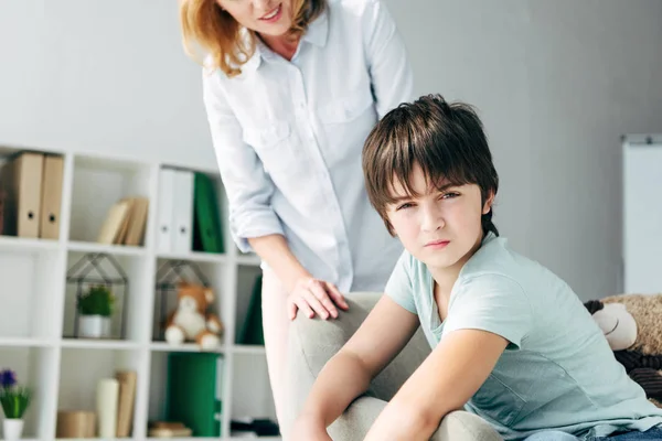 Vista ritagliata di psicologo infantile guardando bambino con dislessia — Foto stock