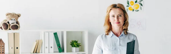 Panoramic shot of attractive child psychologist in shirt looking at camera — Stock Photo