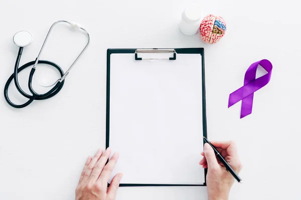 Cropped view of adult doctor holding pen and clipboard — Stock Photo