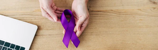Panoramic shot of doctor holding purple ribbon in clinic — Stock Photo