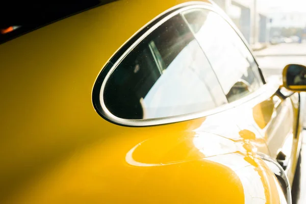 QUIIV, UCRÂNIA - OUTUBRO 7, 2019: foco seletivo da luz do sol nas janelas do carro de porshe amarelo — Fotografia de Stock