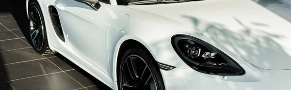 KYIV, UKRAINE - OCTOBER 7, 2019: panoramic shot of shadows on white luxury porshe in car showroom — Stock Photo