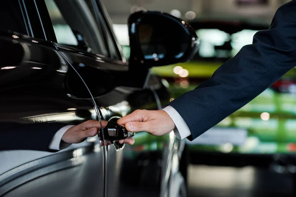 KYIV, UKRAINE - 7 OCTOBRE 2019 : vue recadrée de l'homme ouvrant la porte de la voiture du porche noir — Photo de stock