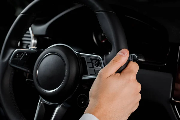 KYIV, UKRAINE - OCTOBER 7, 2019: cropped view of man holding steering wheel in porshe — Stock Photo