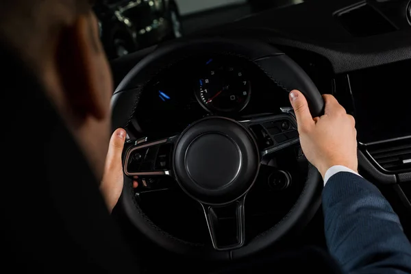 KYIV, UKRAINE - 7 OCTOBRE 2019 : vue recadrée de l'homme tenant le volant dans un porche de luxe — Photo de stock