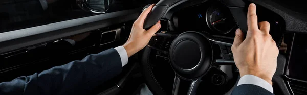 KYIV, UKRAINE - OCTOBER 7, 2019: panoramic shot of driver touching steering wheel while sitting in porshe — Stock Photo