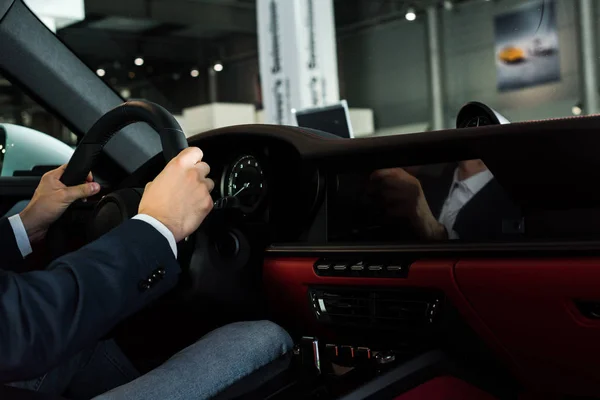 KYIV, UKRAINE - OCTOBER 7, 2019: cropped view of man holding steering wheel in modern porshe — Stock Photo