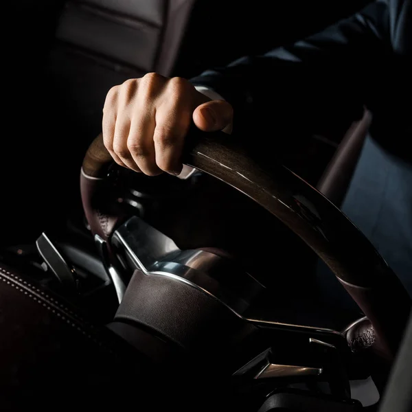 KYIV, UCRANIA - 7 DE OCTUBRE DE 2019: vista recortada del hombre tocando el volante de lujo en porshe - foto de stock