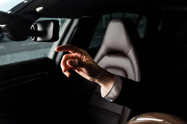 КИЕВ, УКРАИНА - 7 ОКТЯБРЯ 2019 года: обрезанный вид человека, указывающего пальцем на зеркало автомобиля в порше — стоковое фото