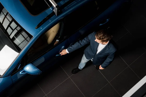 KYIV, UKRAINE - 7 OCTOBRE 2019 : vue de dessus de l'homme d'affaires debout près du porche bleu lors de l'ouverture de la porte de la voiture — Photo de stock