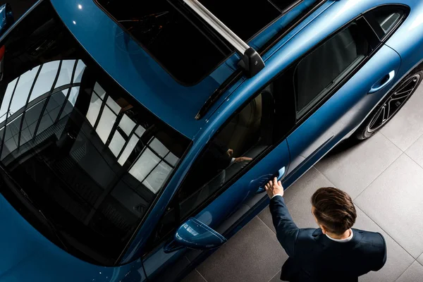 QUIIV, UCRÂNIA - OUTUBRO 7, 2019: vista superior do empresário de terno de pé perto porshe ao abrir a porta do carro — Fotografia de Stock