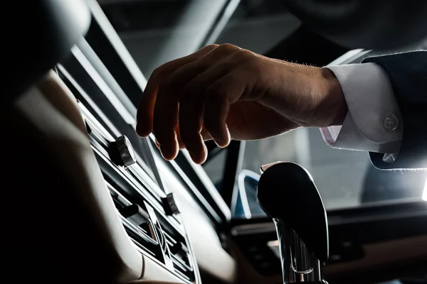 KYIV, UKRAINE - OCTOBER 7, 2019: cropped view of man near gear shift and air conditioner in modern porshe — Stock Photo