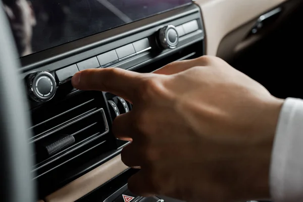 KYIV, UKRAINE - OCTOBER 7, 2019: cropped view of man pointing with finger at button in porshe — Stock Photo