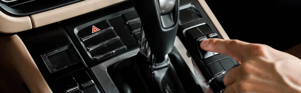 KYIV, UKRAINE - OCTOBER 7, 2019: panoramic shot of man pointing with finger at button near gear shift in porshe — Stock Photo