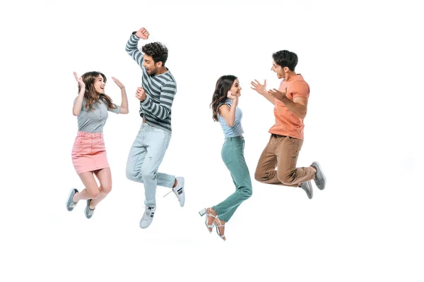 Excited beautiful friends jumping with triumph, isolated on white — Stock Photo