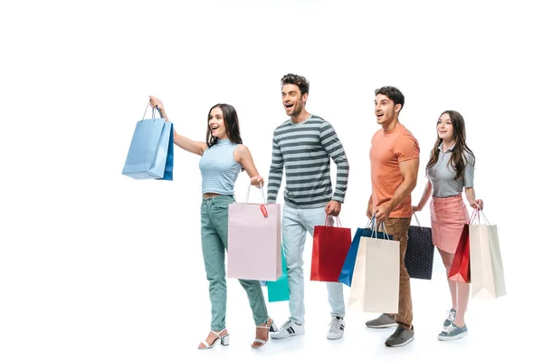 Excited friends walking with shopping bags together, isolated on white — Stock Photo
