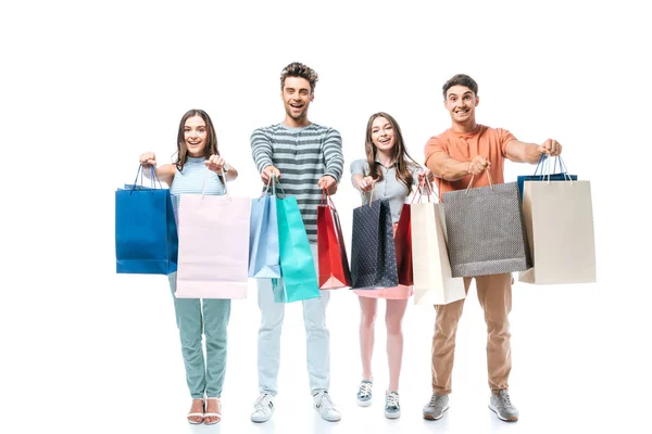 Amigos animados segurando sacos de compras juntos, isolados em branco — Fotografia de Stock