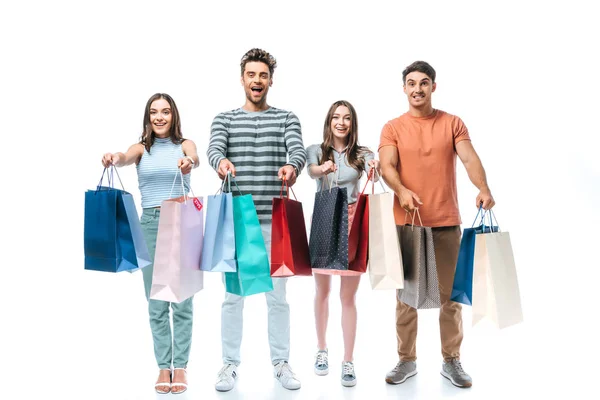 Hermosos amigos sosteniendo bolsas de compras con carteles de venta, aislados en blanco - foto de stock