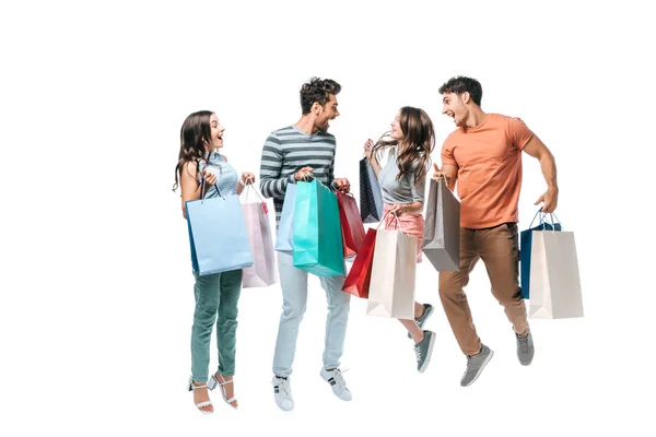 Amis excités sautant et criant avec des sacs à provisions, isolé sur blanc — Photo de stock