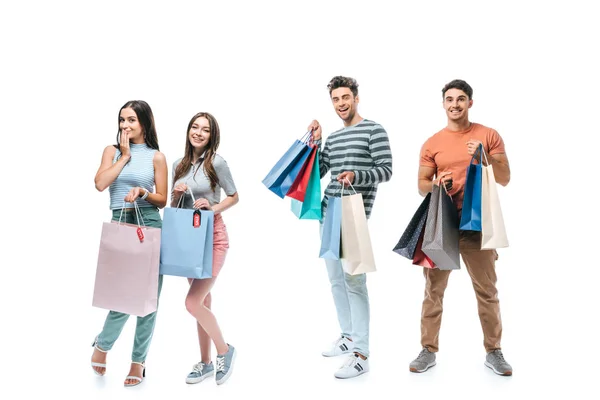 Positive friends holding shopping bags with sale signs, isolated on white — Stock Photo