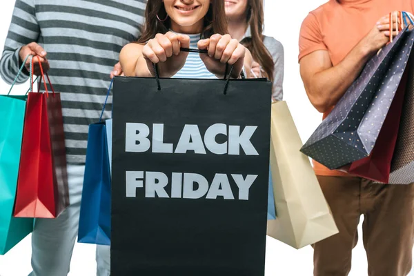 Vista recortada de amigos sosteniendo bolsas de compras el viernes negro juntos, aislado en blanco - foto de stock