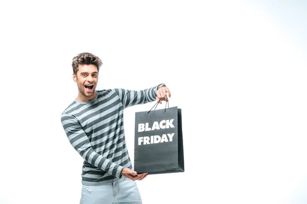 Hombre excitado sosteniendo bolsa de compras el viernes negro, aislado en blanco - foto de stock