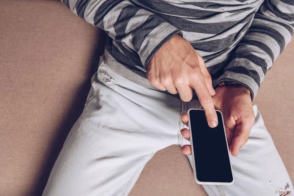 Vista recortada del hombre utilizando el teléfono inteligente con pantalla en blanco - foto de stock