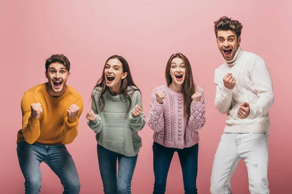 Веселые взволнованные друзья в свитерах кричат изолированные на розовый — стоковое фото