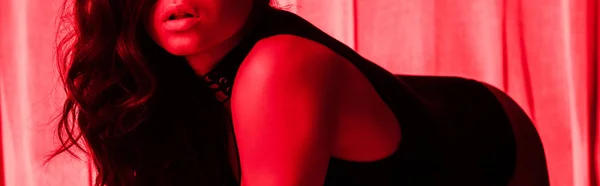 Cropped view of beautiful sexy girl posing in red light, panoramic shot — Stock Photo