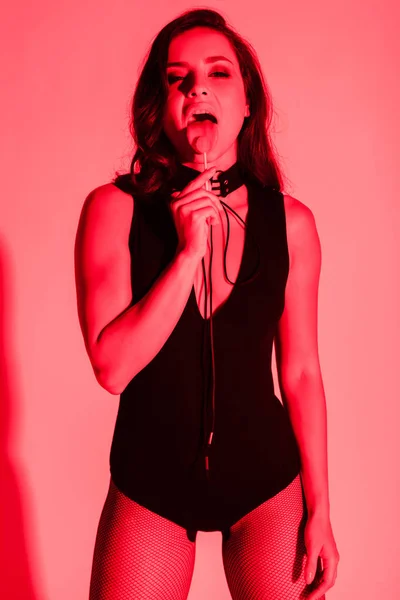 Bella donna sexy mangiare lecca-lecca a luce rossa — Foto stock