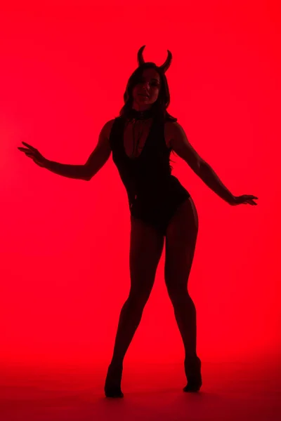 Silhouette de belle femme sexy en costume de diable, isolé sur rouge — Photo de stock