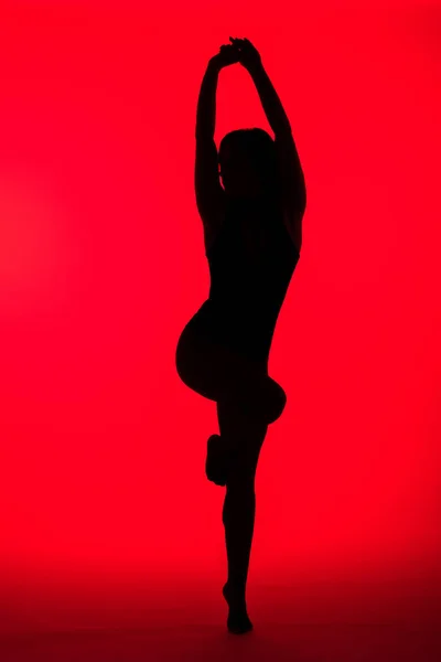 Silhouette nera della ragazza sensuale sul rosso — Foto stock