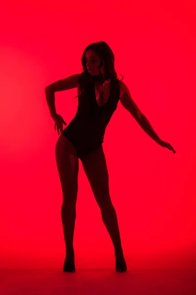 Silhouette de belle jeune femme séduisante, isolée sur rouge — Photo de stock